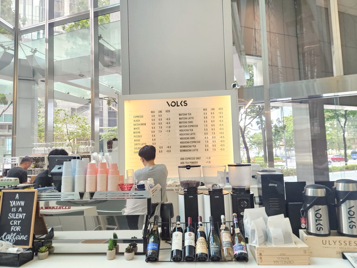 Behind the counter — menu board, wine bottles, and cups